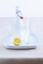 Ceramic bottle lemonade glass and lemon on tray