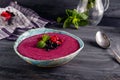 Ceramic bowl with berry smoothie decorated with currant, raspberry and mint on the black wooden background - Well being, Healthy e Royalty Free Stock Photo