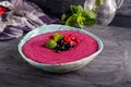 Ceramic bowl with berry smoothie decorated with currant, raspberry and mint on the black wooden background - Well being, Healthy e Royalty Free Stock Photo