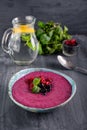 Ceramic bowl with berry smoothie decorated with currant, raspberry and mint on the black wooden background - Well being, Healthy e Royalty Free Stock Photo