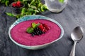 Ceramic bowl with berry smoothie decorated with currant, raspberry and mint on the black wooden background - Well being, Healthy e Royalty Free Stock Photo