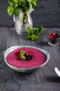 Ceramic bowl with berry smoothie decorated with currant, raspberry and mint on the black wooden background - Well being, Healthy e Royalty Free Stock Photo