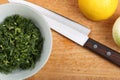 Ceramic bowl with chopped dill leaves, lemon, onion and kitchen knife on a wooden board Royalty Free Stock Photo