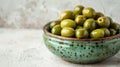 a ceramic bowl filled with fresh green olives
