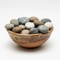 A ceramic bowl filled with smooth, rounded stones of various earth tones including Royalty Free Stock Photo