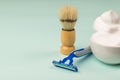 Ceramic bowl with lots of shaving foam  shaving brush and razor on a blue background Royalty Free Stock Photo