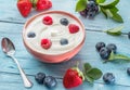 Ceramic bowl with plain yoghurt and berries on the table. Light summer mood