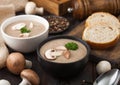 Ceramic bowl plates of creamy chestnut champignon mushroom soup with spoon, pepper and kitchen cloth on dark wooden  background Royalty Free Stock Photo