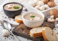 Ceramic bowl plates of creamy chestnut champignon mushroom soup with spoon, pepper and kitchen cloth on white kitchen  background Royalty Free Stock Photo