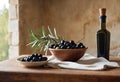 Ceramic bowls full of selected black olives and glass bottle of extra virgin olive oil stand on wooden table.Concept of