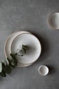 Ceramic bowls and plates on a dark background. Craft ceramic plates and bowls on a concrete table. Top view Royalty Free Stock Photo