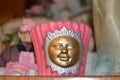 Ceramic candle holder with golden smiling sun on a indoors table