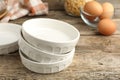 Ceramic casseroles and eggs on wooden table, closeup Royalty Free Stock Photo