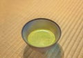 Ceramic Chawan Cup of Japanese Matcha green tea on a tatami mat.