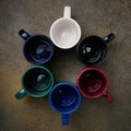 Ceramic colored mugs standing in a circle, close up, top view Royalty Free Stock Photo