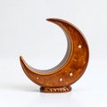 Ceramic crescent moon sculpture with star perforations, warm celestial light on white background Royalty Free Stock Photo