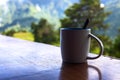 Ceramic cup of coffee on balcony with summer nature background. Relaxing breakfast in mountain lodge Royalty Free Stock Photo