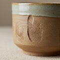 Ceramic cup with a textured, earthy brown surface featuring embossed fingerprint Royalty Free Stock Photo