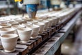 Ceramic cups on assembly line in porcelain manufacturing plant