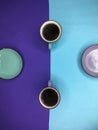 Ceramic cups with tea stand on a blue and lilac background