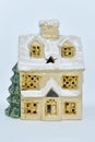 Ceramic decor: a Christmas toy house with a Christmas tree on a white background. Vintage decorative candlestick in the form of a Royalty Free Stock Photo