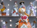 Ceramic doll in an antique lush dress and with heart in hand