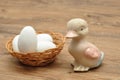 A ceramic duck with a basket filled with white easter eggs Royalty Free Stock Photo