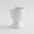 Ceramic egg cup with a glossy white finish on a plain white background. The cup Royalty Free Stock Photo