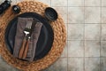 Ceramic empty black plate, silverware and linen kitchen towel napkin on old ceramic tile table background. Cooking stone backdrop Royalty Free Stock Photo