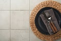 Ceramic empty black plate, silverware and linen kitchen towel napkin on old ceramic tile table background. Cooking stone backdrop Royalty Free Stock Photo