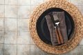 Ceramic empty black plate, silverware and linen kitchen towel napkin on old ceramic tile table background. Cooking stone backdrop Royalty Free Stock Photo