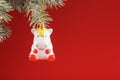 Ceramic Figure of a Unicorn on a spruce branch, on a red background. Free space for text