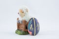 Ceramic figurine of an Easter lamb with an egg next to it on a white background Royalty Free Stock Photo