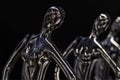 Ceramic figurines of elegant dancing girls on dark background. Front view. Isolate. Close up.