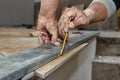 Ceramic floor tiles - man hands marking tile to be cut, closeup Royalty Free Stock Photo