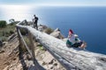 Ceramic gnome lying on a fence at the Cerro Gordo viewpoint with the sea and a man in the background Royalty Free Stock Photo