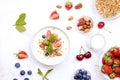 Ceramic granola bowl, assorted ingredients on table. Healthy nutritious breakfast with vegan yogurt, raw fruits, nuts and cereals. Royalty Free Stock Photo