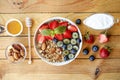 Ceramic granola bowl, assorted ingredients on table. Healthy nutritious breakfast with vegan yogurt, raw fruits, nuts and cereals. Royalty Free Stock Photo