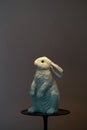 Ceramic hare for home interior decoration. White rabbit on black stand