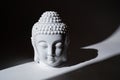 Ceramic head of Buddha statue in the ray of light. Royalty Free Stock Photo