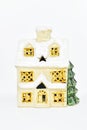 ceramic house with Christmas tree on white background. vintage toy house with snow covered roof