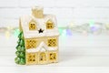 ceramic house with Christmas tree on white background. vintage toy house with snow covered roof