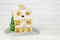 ceramic house with Christmas tree on white background. vintage toy house with snow covered roof