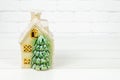 ceramic house with Christmas tree on white background. vintage toy house with snow covered roof