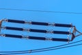 Ceramic insulators on a high voltage pole against a blue sky background. Royalty Free Stock Photo