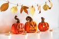 Ceramic Jack Lanterns and autumn leaves garland. Halloween composition. Home decor Royalty Free Stock Photo