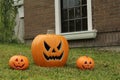 Ceramic Jack O`Lanterns on front lawn of house. Traditional Halloween decor