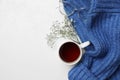 Ceramic mug with aromatic tea, blue knitted sweater, glasses and beautiful dry flowers on white background, flat lay. Space for Royalty Free Stock Photo