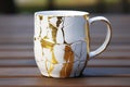 ceramic mug with cracks repaired with gold kintsugi