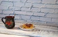 Ceramic mug with a drink and a plate with Viennese waffles and strawberry jam
